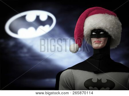 OCT 27 2018:  Portrait of Batman wearing a Santa Claus hat with the Bat Signal, Gotham City - DC Comics - Mego action figure