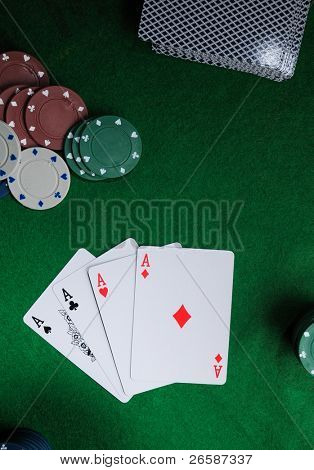Pozadí se čtyři esa, přehrání karty a poker žetony.