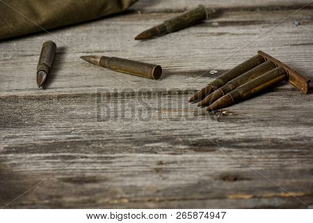 Disassembled Clip With Cartridges 7, 92 X 57 - Rustic Ammos And Poncho Lies On The Wooden Background