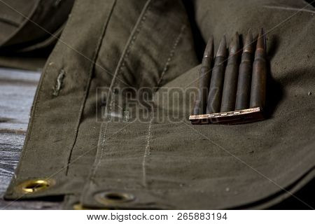 Holder With Cartridges 7, 92 X 57 - Rustic Ammos And Poncho Lies On The Wooden Background