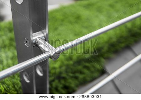 Details Of Fence Made Of Stainless Steel Profile With An Artificial Raffa On The Background.