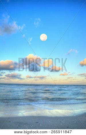 Moonset Over The Ocean At Vanderbilt Beach At Sunset