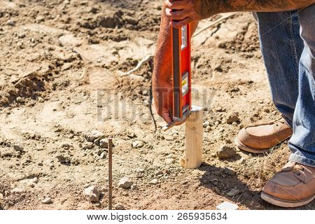 Worker Using Level At Constrcution Site