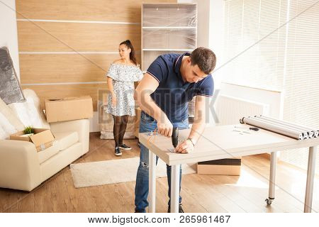 Man Uses Tools To Assembly Furniture In New House.
