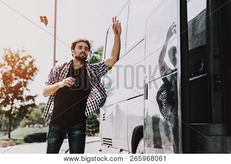 Young Handsome Tourist Almost Late For Bus. Man With Backpack Running After Tour Bus And Asking Bus 