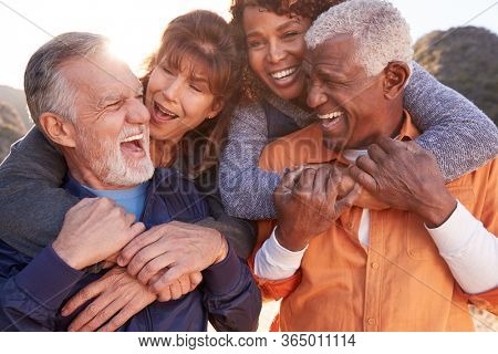 Smiling Senior Friends Having Fun Walking In Countryside Together