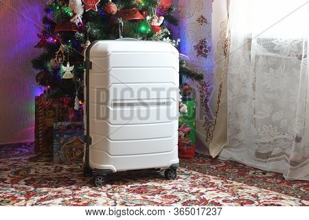 Belarus, Brest - January 9, 2020: A White Suitcase Samsonite Stands Near The Christmas Tree As A Gif