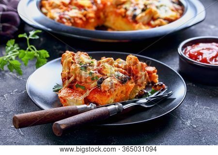 A Portion Of South American Chicken Tamale Pie Or Chicken Casserole With Masa Crust, Cheddar Cheese,