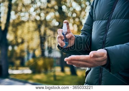 Cropped Close-up Snapshot Of Hands Of Woman Wiping Her Hands With Alcohol Based Spray As Preventive 