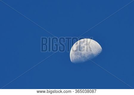 Moon Over Blue Sky Background / The Moon As It Appears Early In Its First Quarter Or Late In Its Las