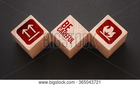 Wooden Cubes With The Text: Be Carefull And Icons Meaning Flamable And No Turing Upside Down. Beware