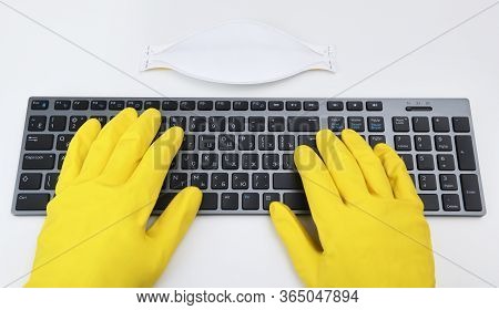A Man In Bright Yellow Rubber Gloves Is Typing On The Keyboard. Disinfection In Public Places, The F