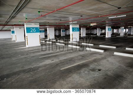 Empty Space Car Park Interior At Afternoon. Indoor Parking Lot. Interior Of Parking Garage With Car 