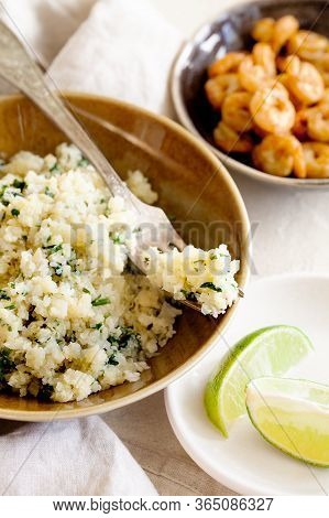 Cauliflower Low-carb Rice Or Couscous With Chopped Cilantro And Lime In A Brown Bowl Close-up.health