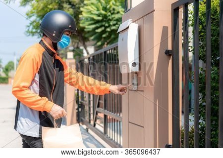 Delivery Asian Man Wear Protective Mask In Orange Uniform And Ready To Send Delivering Food Bag In F
