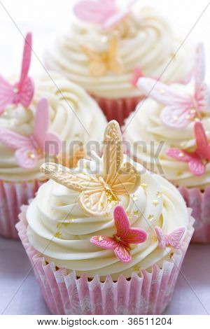 Cupcakes decorati con farfalle rosa e oro fondente