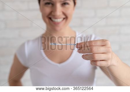 Happy Woman Shows A Positive Ovulation Test. The Concept Of Female Fertility And High Luteinizing Ho