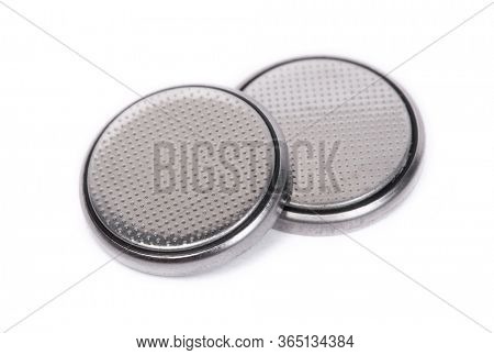 Flat lithium round button cell battery isolated over white background