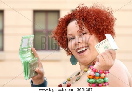 Mujer con el pelo rizado rojo con dinero