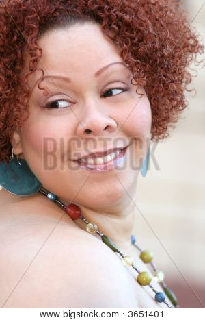Mujer con cabello rizado rojo y joyas brillantes