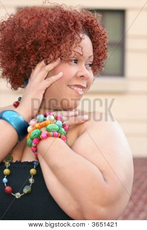 Mujer con cabello rizado rojo y joyas brillantes