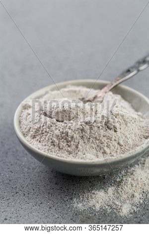 Glutenfree buckwheat flour for baking in the bowl on grey background