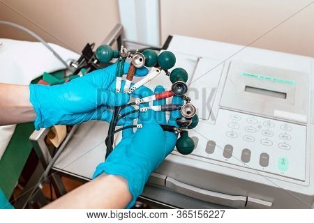 Close-up Of Medical Professional Hands Holding Electrodes Of Ecg Machine. Medical Services In Corona