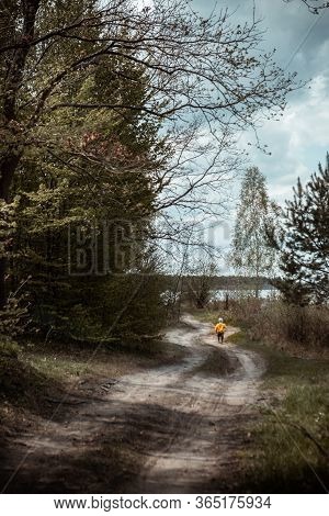 Little Kid In Yellow Coat Running By Forest Trail Footpath