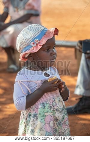 African child  eating biscuits in the yard in a village in Botswana