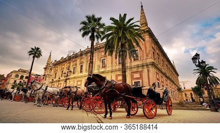 Seville, Spain - 10 February 2020 : Horses And Carriages Waiting For Tourists For A Ride In Beautifu