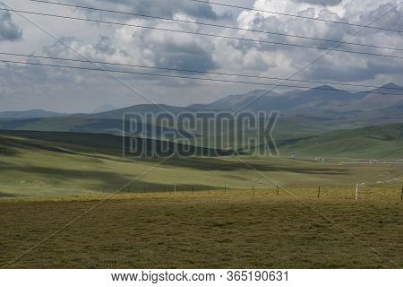 Sunlight Shines Through The Dark Clouds On The Qilian Mountain Meadow
