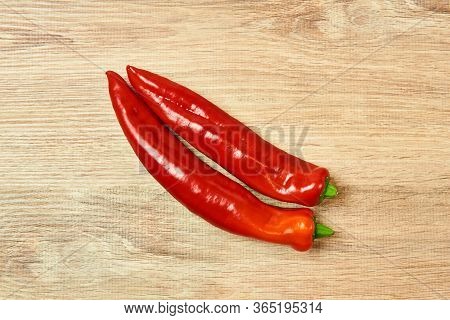 Two Pods Of Sweet Red Pepper Lie On The Table