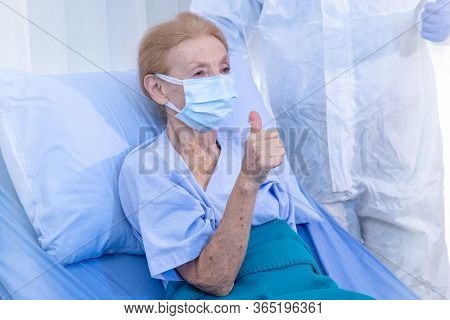 Old Woman Patient Hold Mini Heart On A Wheelchair With Background Of The Medical Team Thumbs Up Afte