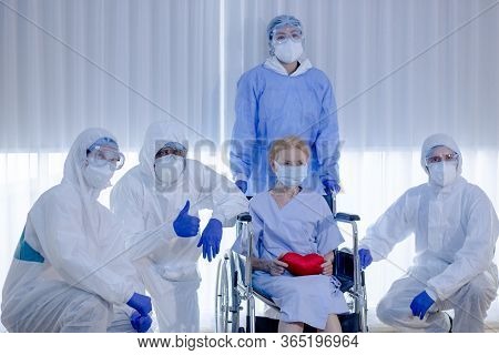 Old Woman Patient Hold Mini Heart On A Wheelchair With Background Of The Medical Team Thumbs Up Afte