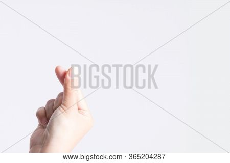 Close-up Of A Hand Signs Gesture To Be Mini Heart Shape From The Tip Of Thumb And Index Finger On Wh
