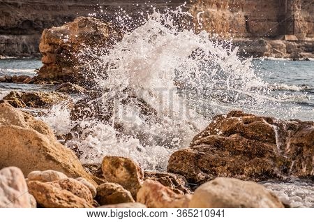 Splitting Waves Against Picturesque Rocks In The Sea