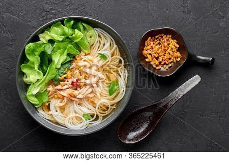 Guay Tiew Gai Cheek Or Thai Chicken Noodle Soup In Black Bowl On Dark Slate Backdrop. Guay Tiew Gai