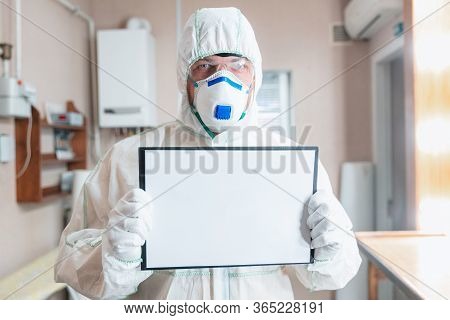 Coronavirus Pandemic. A Disinfector In A Protective Suit And Mask Sprays Disinfectants In House Or O