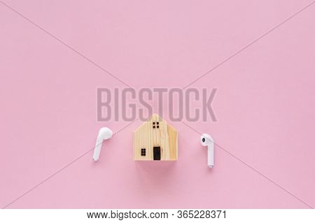 Wooden House Model With Wireless Headphones On Pink Background With Copy Space For Time To Relax,  S