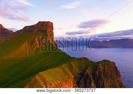 Kallur lighthouse on green hills of Kalsoy island, Faroe islands, Denmark. Landscape photography
