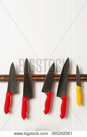 Set Of Knives On Magnetic Strip. Collection Of Knives With Colorful Handles