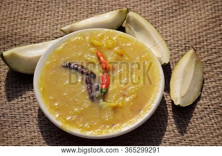 Closeup Of Mango Chutney Cuisine In Plate With Raw Mango Cuts On Burlap Background