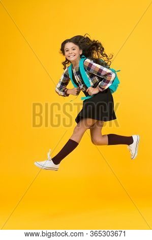 Enjoy School Holidays. Happy Girl Run From School. Little Child In Midair Yellow Background. School 