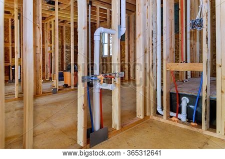 Applying Pipe Drain Plumbing With Hot Red And Cold Blue Pex Pipe Inside A House Bathroom Frame