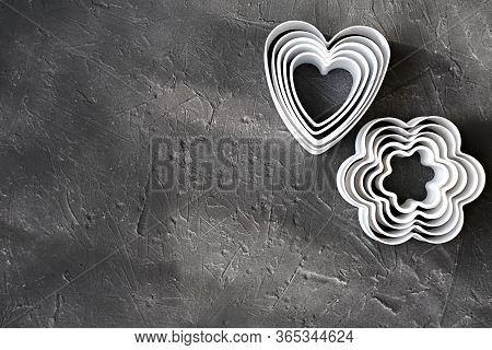 Cookie Cutters On Grey Background. Heart Shaped Cookie Cutters And Flower Shaped Cutter For Baking. 