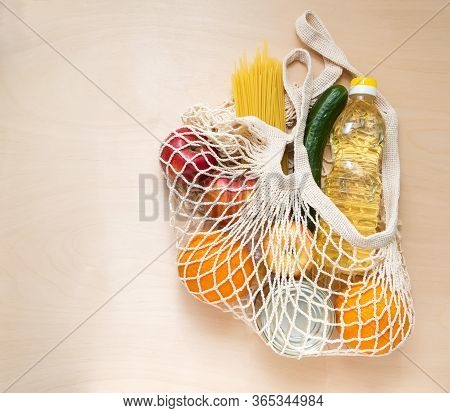 Food Delivery. The Bag Net With Food On The Wood Background: Oil, Spaghetti, Apple, Orang, Cucumber,
