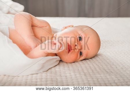Newborn On The Bed. Crying, Screaming Baby Close Up And Copy Space. Baby Smile And Colic In Newborns