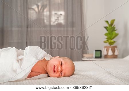 Newborn On The Bed. Crying, Screaming Baby Close Up And Copy Space. Baby Smile And Colic In Newborns