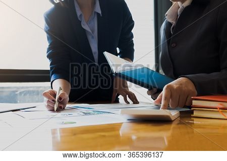 Businessman Pointing Graph Chart With Pathner For Analyze Plans In This Mounth. Vintage Tone.