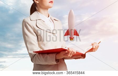 Woman Showing Rocket Ship On Open Book. Rocket Launch As Symbol Startup Company. New Creative Projec